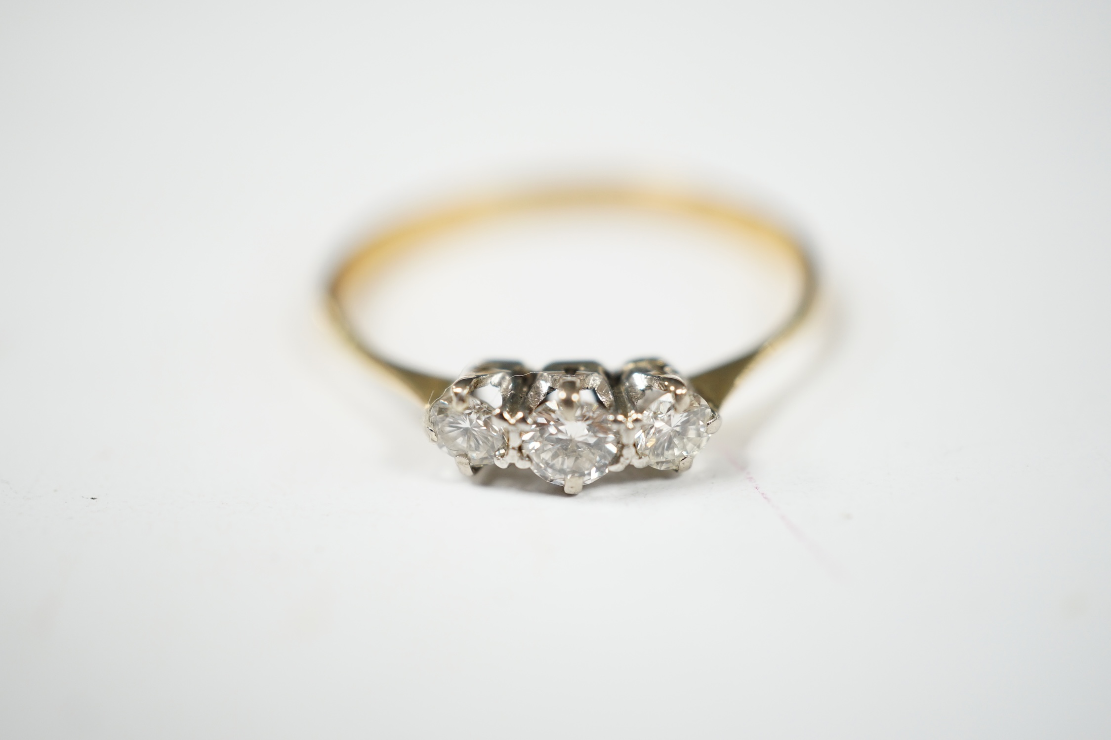 A yellow metal and three stone diamond set ring, size V, gross weight 2.4 grams. Condition - fair